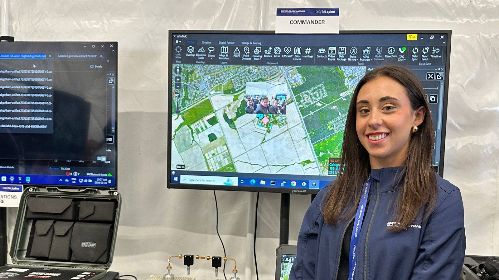 Woman standing in front of screen at CANSEC.