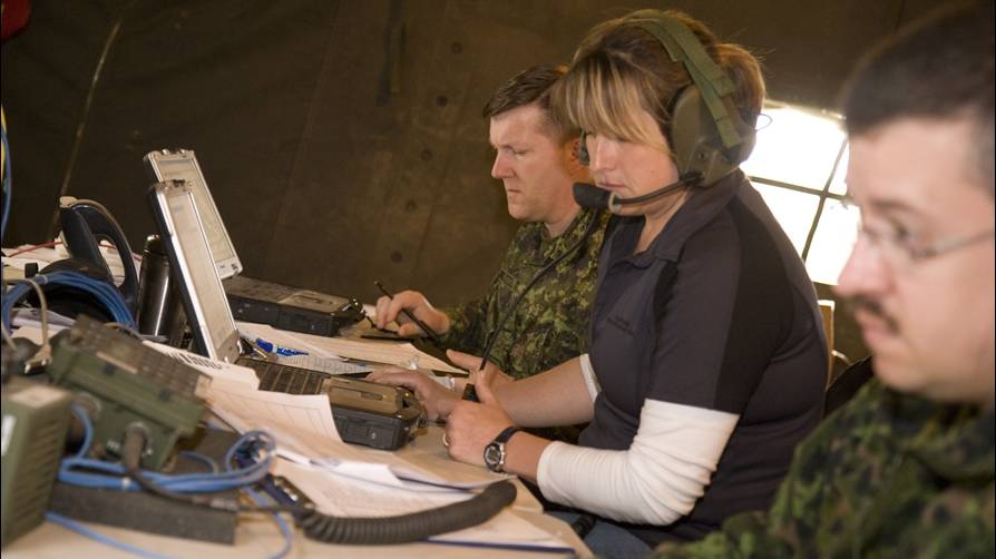 Woman at laptop in military tent