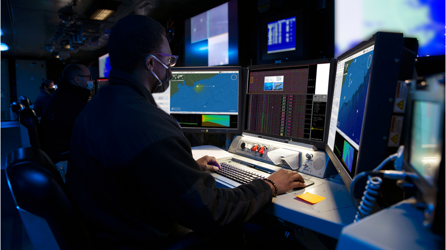 Ship sonar operator in front of screens