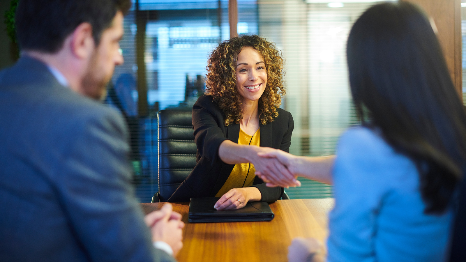 Woman shaking hands with recruiters. 