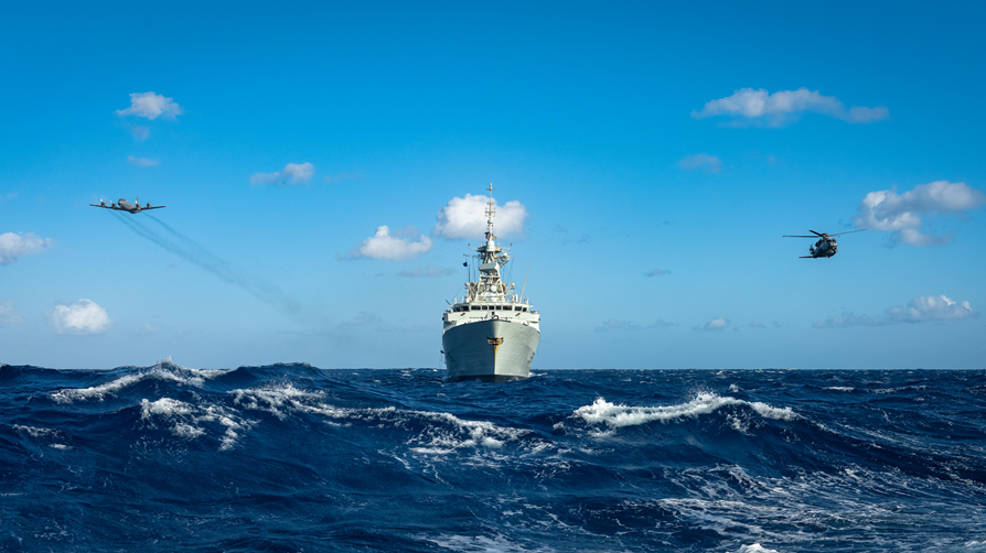 airplane, ship, and helicopter on the ocean