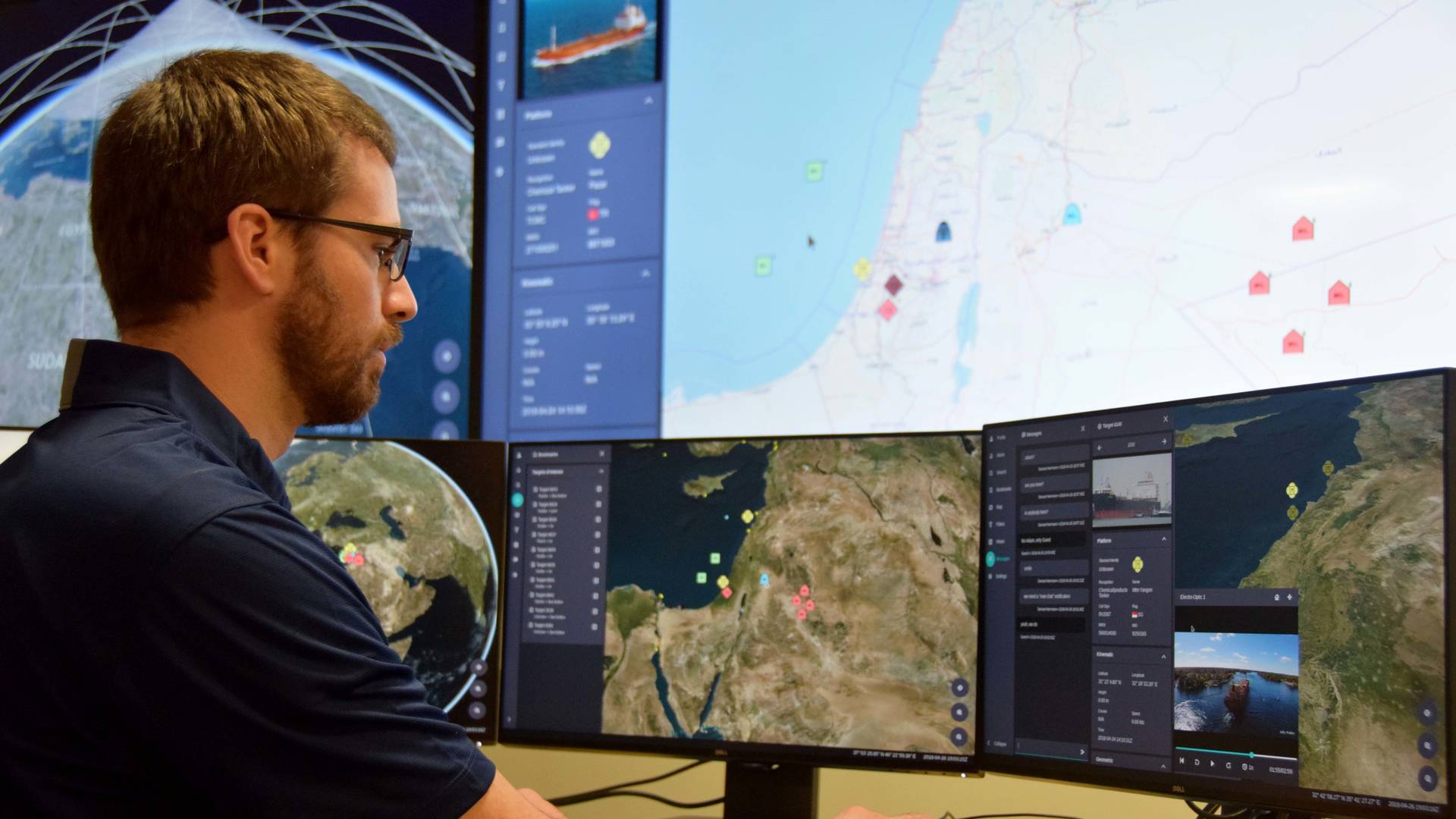 Man looking at several computer displays.